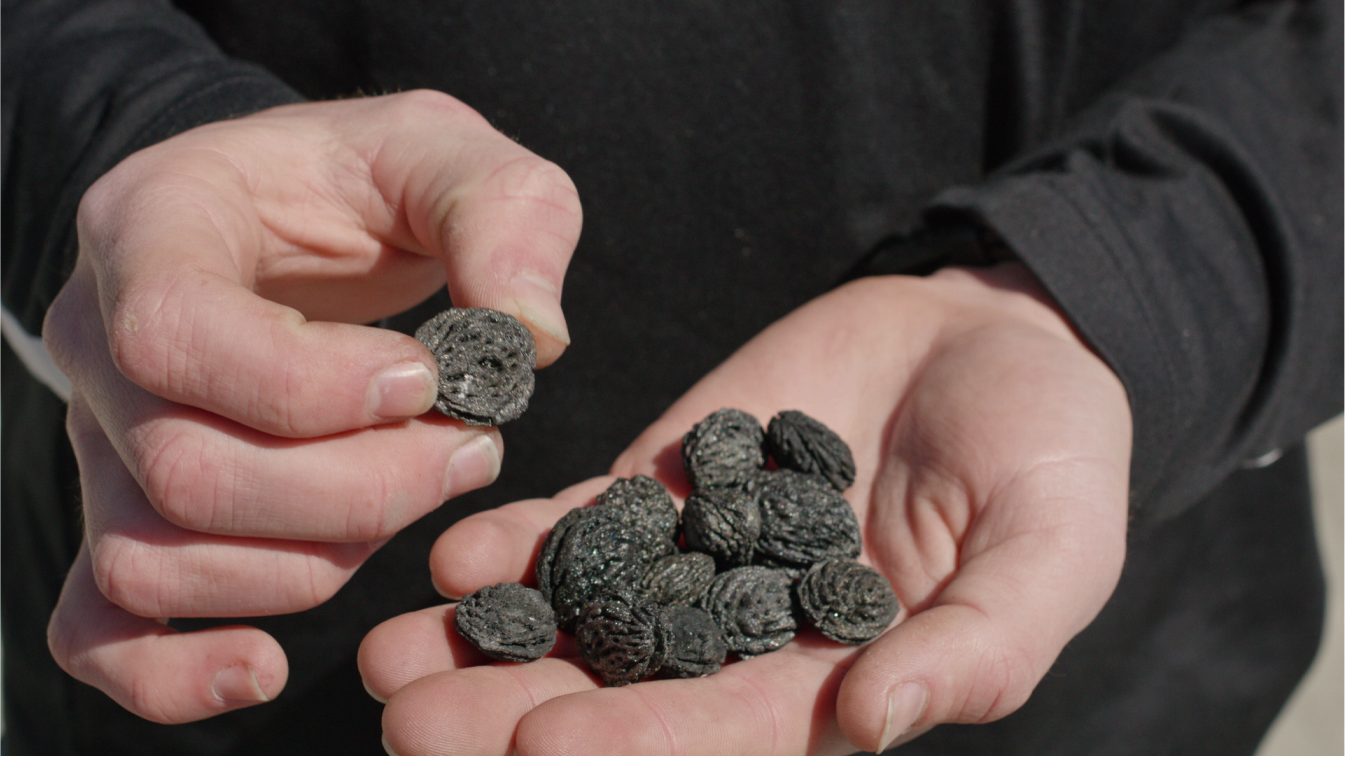 Close-up of a hand full of pure biocarbon chunks